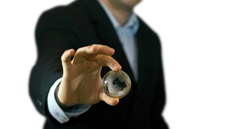 hand holding large glass marble in foreground