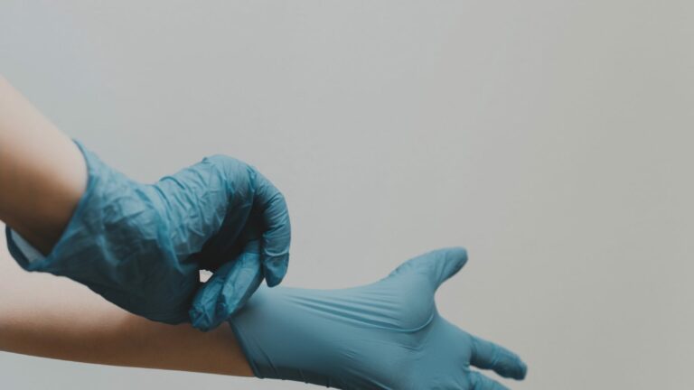 hands wearing blue surgical gloves