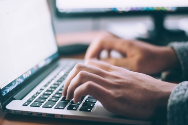 hands typing on laptop keyboard