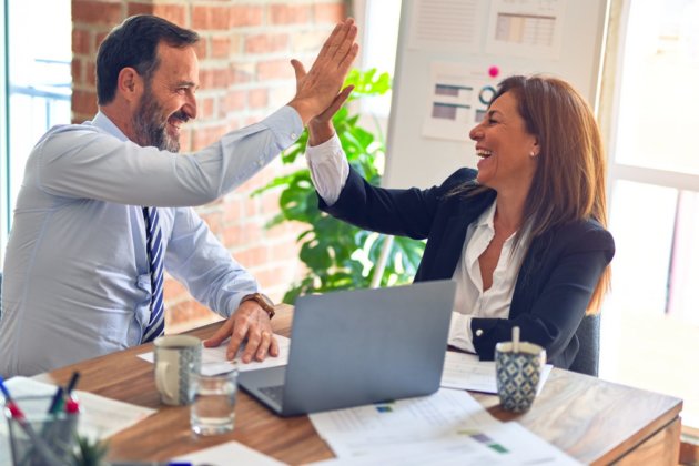 business man and woman 'high five' in office