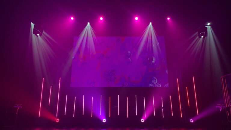 Empty stage flooded with pink and purple lights