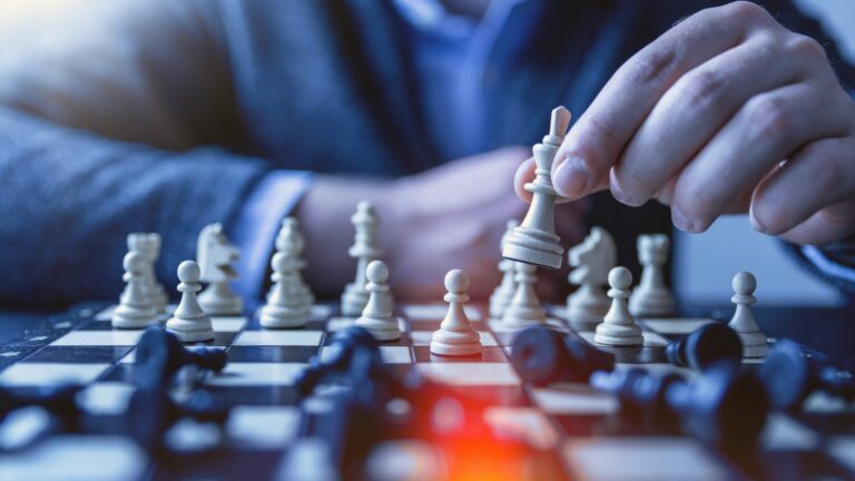 close up of hand moving chess piece