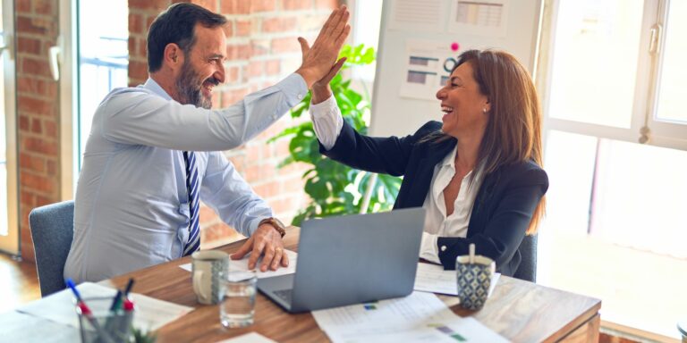business man and woman 'high five' in office