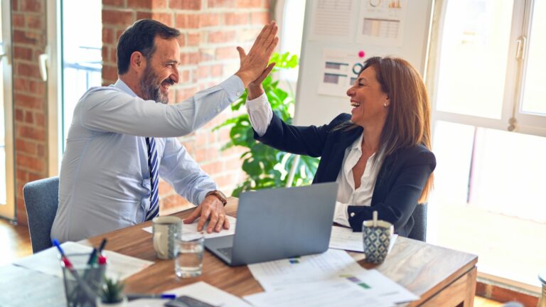 business man and woman 'high five' in office