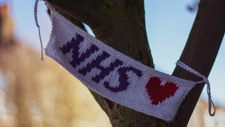 NHS blue, white and red knitted banner tied to a tree