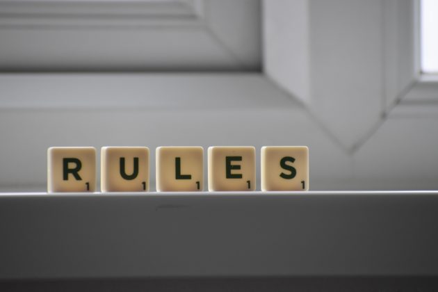 Scrabble letter tiles spelling out the word rules