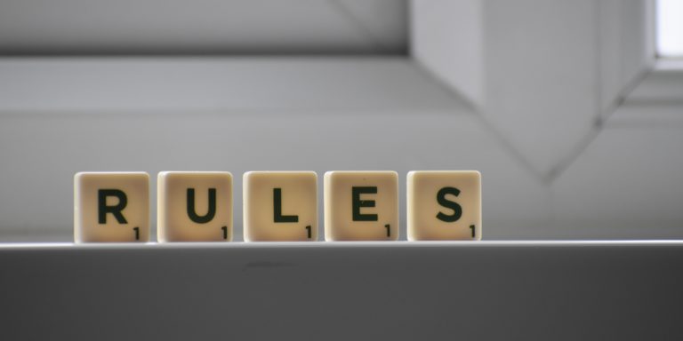 Scrabble letter tiles spelling out the word rules