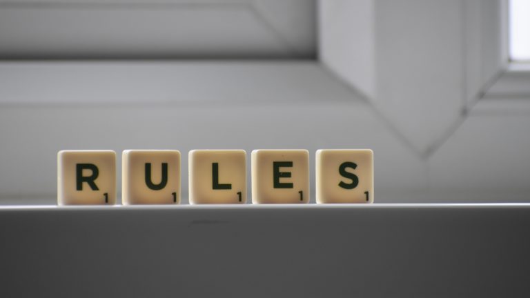 Scrabble letter tiles spelling out the word rules